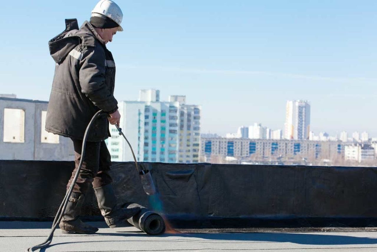 Waterproofing worker on roof